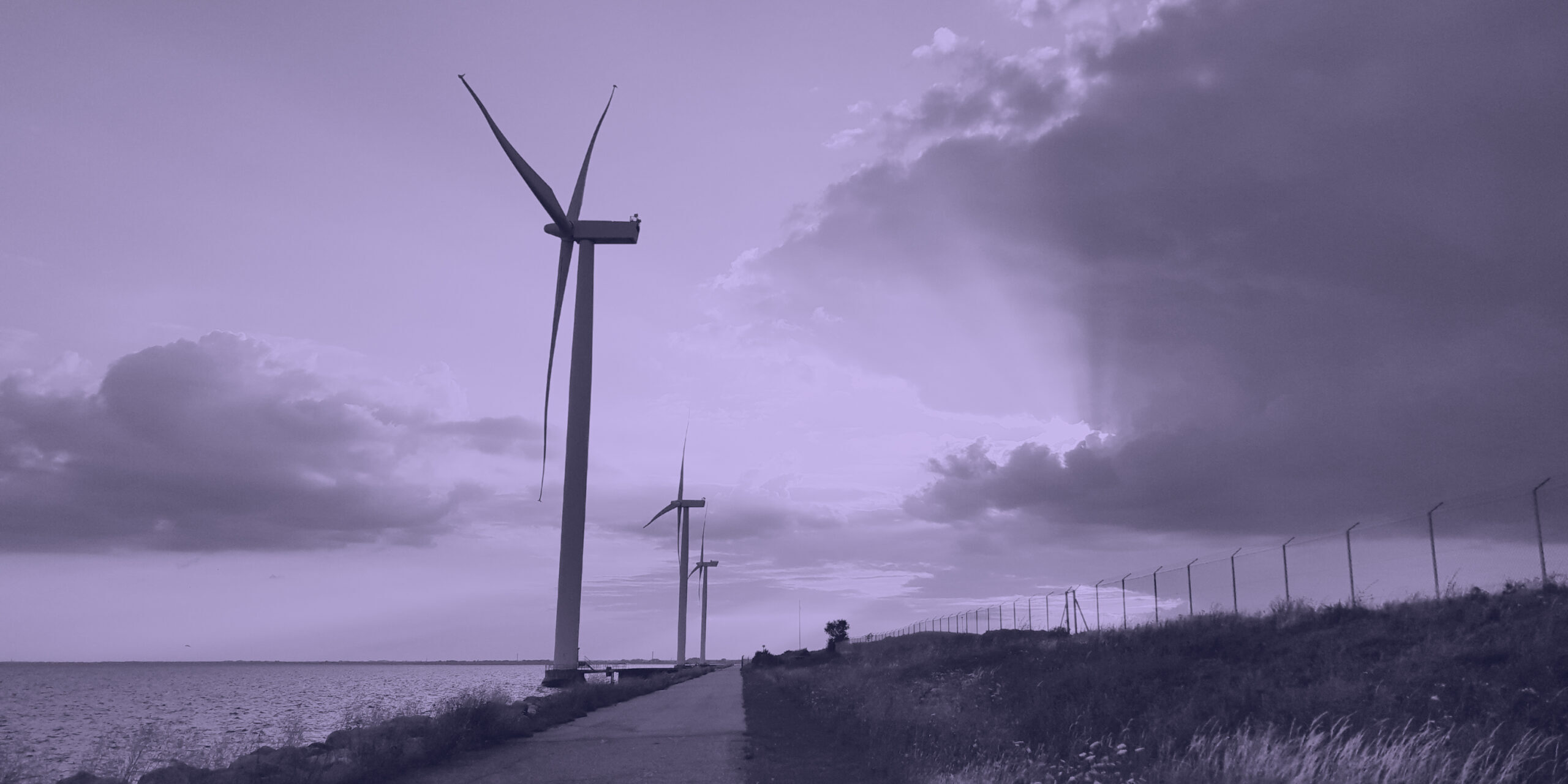 Wind turbines located right on the Danish coast, at sunset.