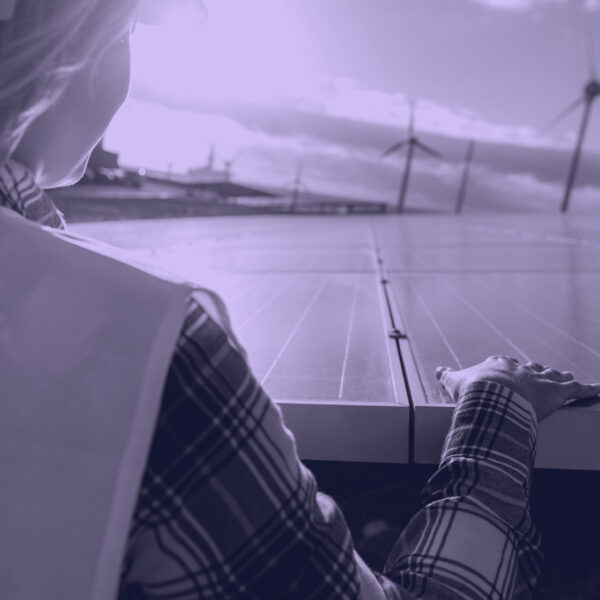 Young female engineer working for alternative energy with wind turbine and photovoltaic solar panel - Innovation and green power concept