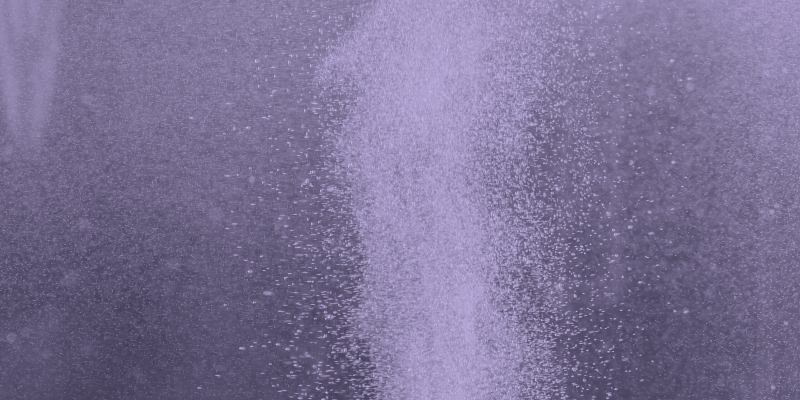 Column of hydrogen bubbles in water against blue background